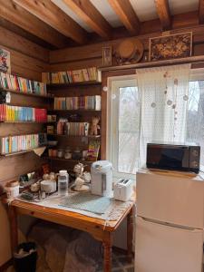 a kitchen with a table with a microwave and a refrigerator at Polar Bear 藏王白熊民宿 in Kaminoyama