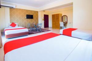 a hotel room with two beds and a table at Hotel D'Sea Princess in Tanjung Bungah