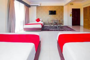 a hotel room with two beds and a table at Hotel D'Sea Princess in Tanjung Bungah