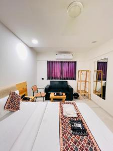 a living room with a bed and a couch at Hotel Royal Manor in Rajkot