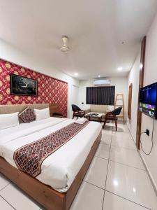 a hotel room with a bed and a television at Hotel Royal Manor in Rajkot