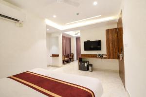 a hotel room with a bed and a flat screen tv at Hotel Prowell Apex - Kondapur in Hyderabad