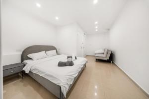 a bedroom with a large bed and a chair at Villa Ella in Eilat