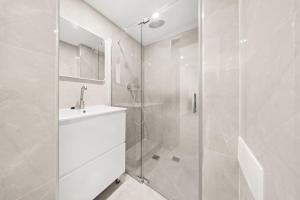 a white bathroom with a shower and a sink at Villa Ella in Eilat +9 photos