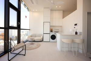 a kitchen and living room with white walls and windows at SunU Seoul Stay - All Rooms 45m Panoramic Han River View - 4m Ceiling in Seoul