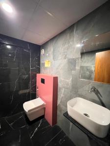 a bathroom with a sink and a toilet in it at Hotel Royal Manor in Rajkot +10 photos