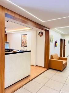 a waiting room with a counter and a couch at Hotel Royal Manor in Rajkot