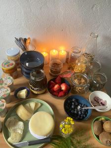 a table topped with plates of food and candles at Quinta WOW in Benfeita