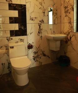 a bathroom with a toilet and a sink at Trinity Homestay Munnar in Anachal +10 photos