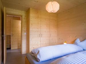 a bedroom with a bed in a wooden wall at Labbrunnu OG in den Walliser Alpen in Rosswald
