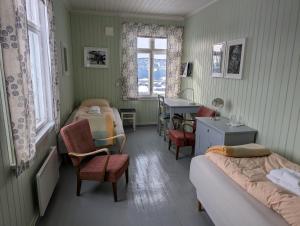 a bedroom with two beds and a desk and a table at Granum Gård in Fluberg