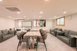 a meeting room with a table and chairs and a screen at Hotel Moon in Jeju