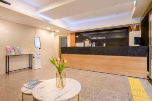 a lobby with a vase of flowers on a table at Hotel Moon in Jeju