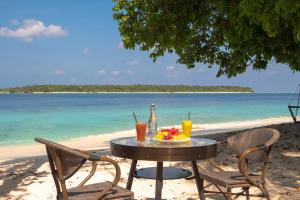 a table with a plate of food on the beach at Thundi Ocean View in Maalhos
