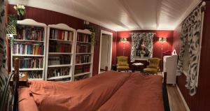 a bedroom with red walls and white book shelves at Låven Parsellhage in Hoset