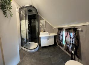 a bathroom with a shower and a sink at Låven Parsellhage in Hoset