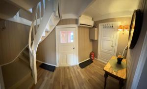 a hallway with a staircase and a white door at Låven Parsellhage in Hoset