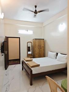 a bedroom with a bed with a ceiling fan at AalaGo in Thiruchendur
