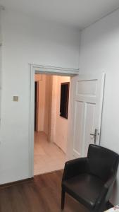 a room with a black chair and a door at Апартамент Луиза in Varna City