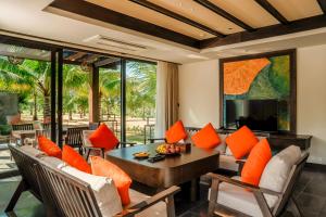 a living room with a couch and a table with orange pillows at Amiana Resort Cam Ranh in Cam Ranh