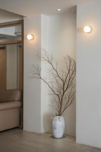 a blue vase with a tree in a room at Mintara Hotel - โรงแรมมินธารา มีนบุรี in Min Buri