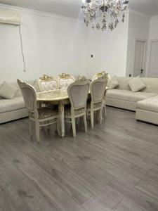 a dining room with a table and chairs and a couch at Dos in Kapchagay