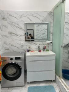 a bathroom with a washing machine and a sink at Dos in Kapchagay +31 photos