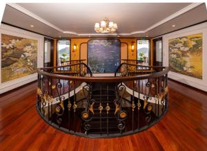 a spiral staircase in a house with paintings on the walls at Cycad cruise in Ha Long