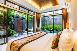 a bedroom with a large bed and large windows at La Paradis Villa in Canggu +139 photos