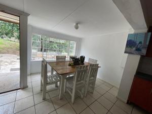 a dining room with a wooden table and chairs at Evergreen Avocado Orchard in Alexandria