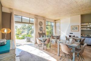 a living room with tables and chairs and a large window at Glen Maine Guest House in Pretoria