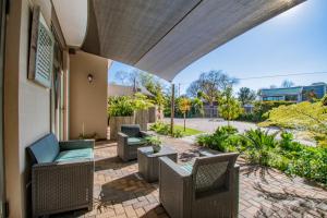 an outdoor patio with chairs and a table at Glen Maine Guest House in Pretoria