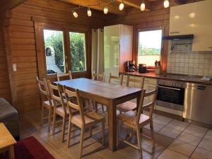 a kitchen with a wooden table and chairs at Blockhaus, Bad Sachsa in Steina