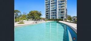 a large swimming pool in front of a large apartment building at Vitamin Sea - Gold Coast luxury on the lagoon in Gold Coast