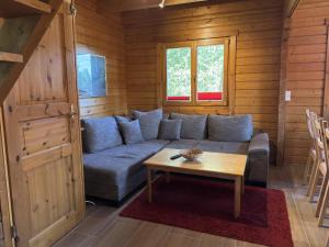 a living room with a blue couch and a table at Blockhaus, Bad Sachsa in Steina