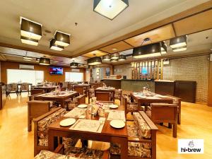 a restaurant with wooden tables and chairs in a room at Hotel Senses in Kolkata