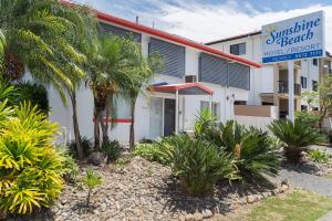 um edifício com palmeiras em frente em Sunshine Beach Resort em Gold Coast