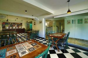 a restaurant with tables and chairs and a checkered floor at Hotel Marigold Mount Abu - With Swimming Pool in Mount Ābu
