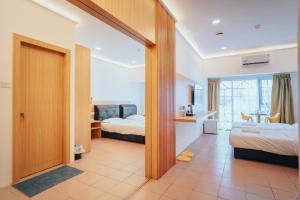 a hotel room with two beds and a bathroom at Hotel Koperasi in Seria
