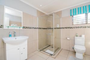 a bathroom with a shower and a toilet and a sink at Glen Maine Guest House in Pretoria +77 photos