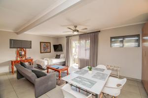 a living room with a couch and a table at Glen Maine Guest House in Pretoria