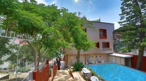 a swimming pool in front of a house at Hotel Marigold Mount Abu - With Swimming Pool in Mount Ābu
