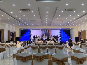 a banquet hall with white chairs and a group of people at Hải Tiến Resort in Mỹ Ðuc