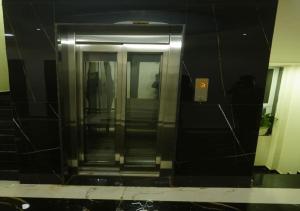 a reflection of an elevator in a building at Shri Hari Executive Lodge in Tuljapur +16 photos