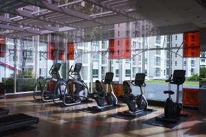 a gym with cardio equipment in front of a large window at PoolView Condo Near MRT, Nice & Quiet, speedy net in Bangkok