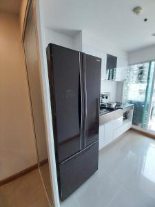 a kitchen with a large black refrigerator in a room at PoolView Condo Near MRT, Nice & Quiet, speedy net in Bangkok