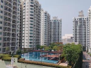 a building with a swimming pool in front of tall buildings at PoolView Condo Near MRT, Nice & Quiet, speedy net in Bangkok