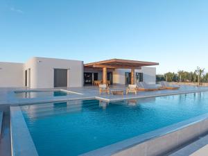 a swimming pool in front of a villa at Villa Kairos in Foiníki