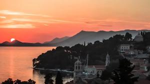 a city on the shore of a lake at sunset at Studio apartment JELI in Cavtat