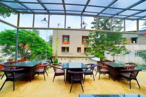 a patio with tables and chairs and a building at Hotel Marigold Mount Abu - With Swimming Pool in Mount Ābu